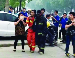 事故現(xiàn)場(chǎng),受傷的消防隊(duì)員被隊(duì)友攙扶到一邊休息 事故現(xiàn)場(chǎng),受傷的消防隊(duì)員被隊(duì)友攙扶到一邊休息