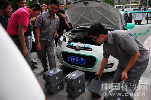 力帆汽車研發生產的電動汽車，工作人員正在為車輛替換電源。